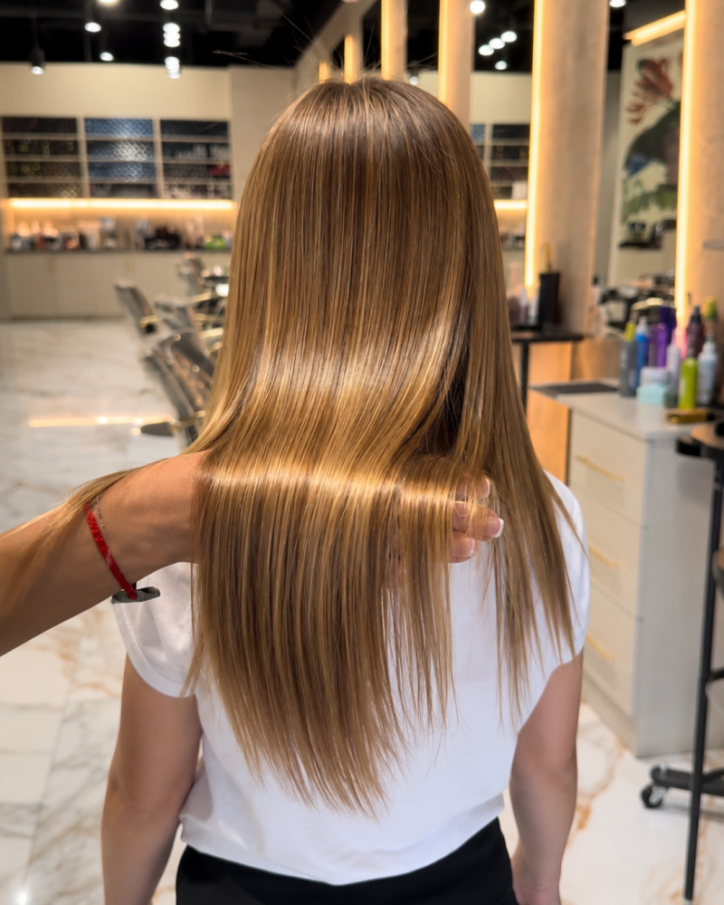 Long golden-brown hair styled at Hairmess Salon