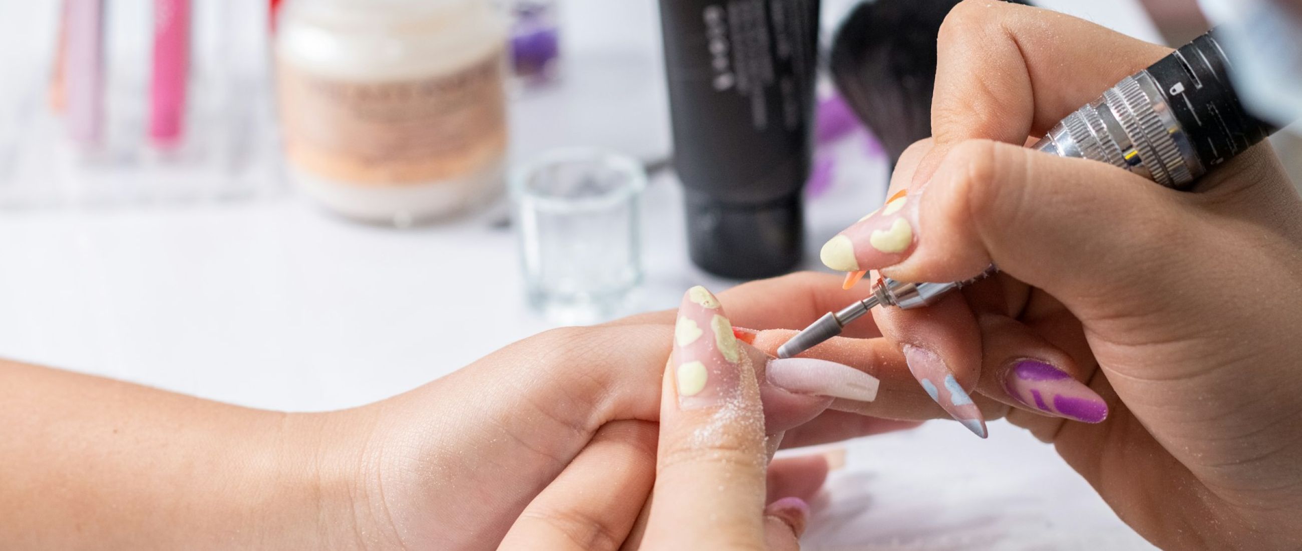 close up of hands filing a woman s nails with a nail file professional manicure service 80cbba3c Nails